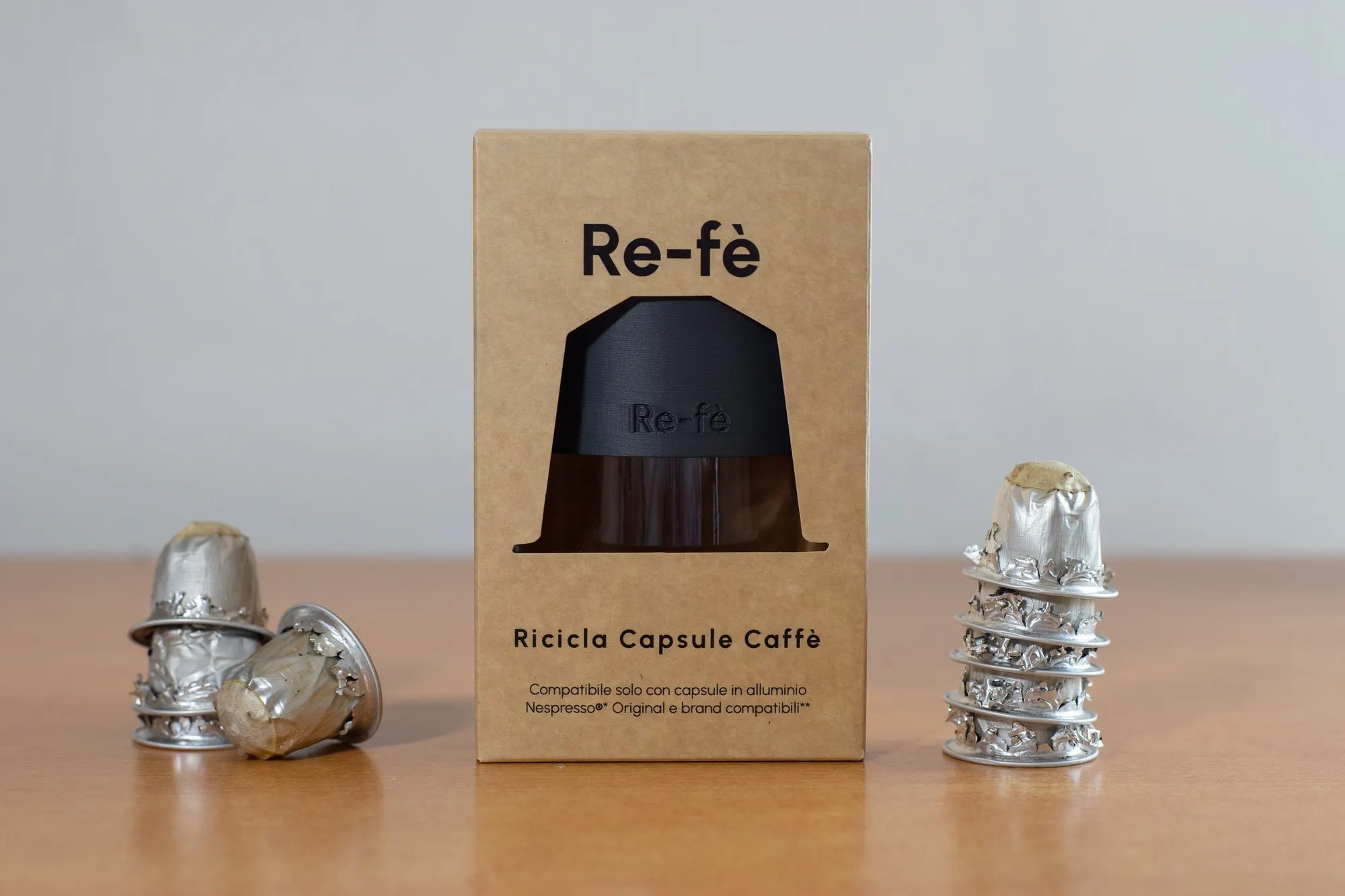 Confezione dell'apricapsule Re-fè Original tra capsule Nespresso in alluminio usate e svuotate